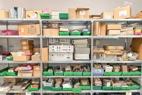 Obsah regálu: náhradní díly strojů pro příčné řezačky