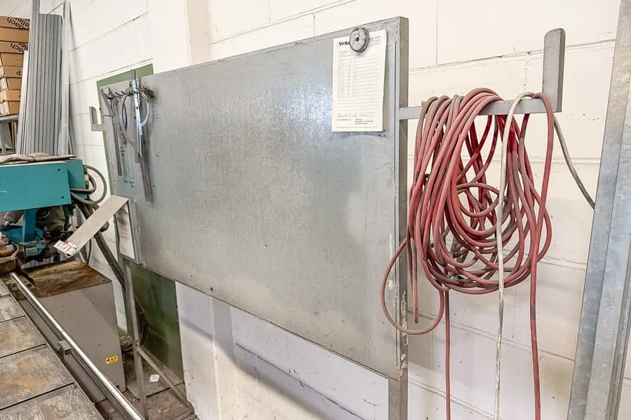 Sheet metal wall with cables, brackets and saw blades