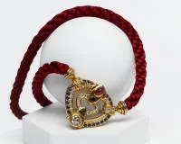 Außergewöhnliches Collier, Auftragsarbeit, 18kt Gelbgold, Brillant ca. 1.20 ct., etwa tw/p1-p2, Rubincabochon 7 x 5 mm, 22 Saphire, 34 kleine Brillanten zus. ca. 1.20 ct., ca. 31.5 g (Anhänger), an Textilkordel mit Wechselschließe, ca. 44 cm lang
