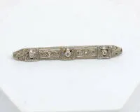 Broszka Art Déco, złoto żółte 18kt/platyna 950, trzy diamenty, małe różyczki diamentowe, ok. 3,3 g, dł. ok. 55 mm