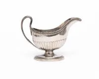 Klassizistische Sauciere, 18./19. Jh., Meistermarke "R.M / R.H", weitere Punzen verputzt, elegant geschweifte Form mit Akanthushenkel und in der unteren Hälfte kanneliertem Korpus, auf ovalem Stand, 13.5 cm hoch, ca. 330 g