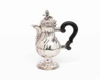 Petite cafetière en argent, Guttstadt (Prusse-Orientale), vers 1750, argent repoussé et fondu ; corps piriforme à godrons multiples sur pied rond profilé et galbé, col élevé avec bec court et incurvé ; couvercle bombé à charnière avec décor de godrons et bouton floral et feuillagé en relief ; poignée latérale en bois noirci avec montures en argent incurvées, H. 16 cm, env. 205 g