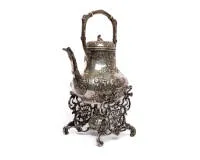 Théière historiciste sur réchaud, argent 800, Weinrack & Schmidt, Hanau, corps piriforme avec anse mobile, riche décor rocaille et floral, deux cartouches ornées de putti musiciens, le réchaud finement ajouré sur pieds en volutes, env. 2.270 g
