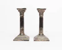 Pair of neoclassical column candlesticks, London, 1963, sterling silver, socket with reeded sides in Corinthian capital of a fluted column shaft on stepped base with square profile, base weighted, H. 18.5 cm, total approx. 811g