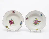 Deux assiettes à soupe, Meissen, marque aux épées, époque Marcolini, 1774 - 1814, aile contournée avec bord violet, peinture florale, ø 22,5 cm/23 cm, une légère fêlure de cuisson dans le bord, un éclat dans l'anneau de base