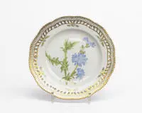 Royal Copenhagen, Flora Danica, assiette ajourée, Copenhague, 1979-1984, numéro de modèle 3553, décor polychrome et riche dorure, aile ajourée avec bord dentelé, au centre représentation de la Chicorée sauvage (Chiorium Intybus L.), au revers...
