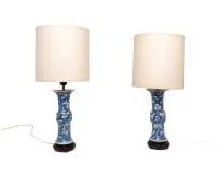 Paar chinesische Vasen als Tischlampen, Kangxi-Stil, um 1900, Blau-weißes Prunus- und Pflaumenblütendekor, helle Lampenschirme, geschnitzte Holzsockel, H. 25.5 cm exkl. Montierung und Sockel, eine Vase mit geklammerter Bruchstelle sowie Chip