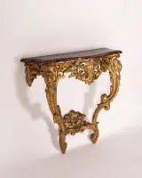 Console en trompe-l'œil, rococo, probablement Italie, milieu du 18e s., piétement en bois richement ajouré et sculpté, doré sur fond rouge, plateau profilé et galbé en bois, peint en faux marbre, 85.5 x 88 x 40 cm, restauré
