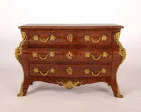 Commode représentative, Régence, France, 1ère moitié du 18e siècle, corps fortement bombé avec trois tiroirs sur ceinture galbée et pieds évasés, riches garnitures dorées avec mascarons latéraux et décor d'acanthe, plateau en marbre rouge...