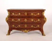 Commode représentative, Régence, France, 1ère moitié du 18e siècle, corps fortement bombé avec trois tiroirs sur ceinture galbée et pieds évasés, riches garnitures dorées avec mascarons latéraux et décor d'acanthe, plateau en marbre rouge...