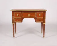 Classicistisch bureau, Louis XVI, Frankrijk, circa 1780, gestempeld onder de voorste rand "J. CAUMONT / JME", mahonie fineer, rijke deels vergulde beslagen, corpus met vijf laden onder uitstekend blad op taps toelopende gecanneleerde...
