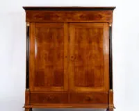 Cabinet, Biedermeier, first third 19th c., cherry, panelled body with two doors and two base drawers, flanking ebonised columns with gilded capitals, shellac polish, approx. 214 x 187 x 68 cm, very good restored condition