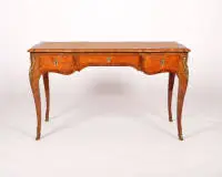 Bureau plat de style Louis XV, France, début 20e s., estampillé "ROESSLE" sous la traverse droite, placage de palissandre et noyer, galbé sur toutes faces, pieds galbés, trois tiroirs, fausses tirants au verso, plateau avec cuir doré, bronzes, serrure signée "Stremler AV Paris", 76 x 131.5 x 71.5 cm