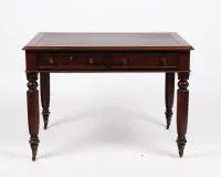 Victorian desk, England, 2nd half 19th c., mahogany veneered, rectangular writing body with rounded corners and two apron drawers, four octagonal baluster legs on brass castors, red-brown leather top with gold embossing, 73.5 x 106 x 73 cm, top with signs of use