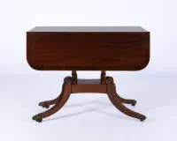 Drop-leaf table, England, 19th/20th c., mahogany among others, side flap with apron drawer on quatrefoil frame with brass castors, 73 x 56 (109) x 93 cm, signs of use