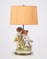 Salonlamp, "Kinderpaar met vogelnest", 20e eeuw, polychrome porseleingroep gemonteerd als lamp, tweelampig, geëlektrificeerd, stoffen kap, 68 cm hoog, haarscheurtjes
