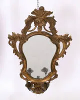 Rococo mirror with candle arm, Italy, circa 1765, frame carved in wood with rich openwork rocaille decoration, from the base grows a two-light iron candle arm with foliage and central flower, 83 x 53 cm, restorations...