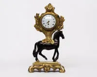 Pendule de table "Cheval", Louis XVI, Paris, vers 1780, sign. "MOILOT A PARIS", bronze, cheval en bronze sur socle à pieds en volutes, de la selle émerge une tête d'horloge entourée de feuilles de laurier avec cadran en émail blanc et index romains, sur le...