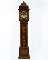 Horloge à poser amstellodamoise, signée "Hendrik Vollenhoven / Amsterdam", vers 1780, transformée plus tard avec un mouvement musical. Boîtier en chêne richement marqueté, marqueterie en ronce de noyer et divers bois précieux, façade avec vases de fleurs, branches fleuries, oiseaux et rinceaux, longue porte de pendule avec lentille métallique ovale ajourée ; tête d'horloge architecturée avec chapiteaux corinthiens et ouvertures sonores latérales, cadran en laiton avec anneau de chiffres romains