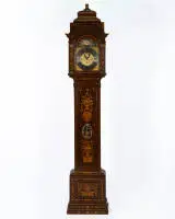 Horloge à poser amstellodamoise, signée "Hendrik Vollenhoven / Amsterdam", vers 1780, transformée plus tard avec un mouvement musical. Boîtier en chêne richement marqueté, marqueterie en ronce de noyer et divers bois précieux, façade avec vases de fleurs, branches fleuries, oiseaux et rinceaux, longue porte de pendule avec lentille métallique ovale ajourée ; tête d'horloge architecturée avec chapiteaux corinthiens et ouvertures sonores latérales, cadran en laiton avec anneau de chiffres romains 