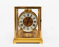 Jaeger-LeCoultre, Atmos table clock, Switzerland, circa 1980, gilded brass case, glazed on five sides, with white Roman numeral ring and blackened hands, visible mechanical movement with automatic winding by temperature changes and...