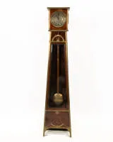 Sierlijke jugendstil staande klok, circa 1910, kast die naar boven toe smaller wordt op korte voeten met vlakke messing applicaties in geometrisch gestileerde boog- en waaiermotieven, deur met gefacetteerd glas, gegraveerde slingerlens,...