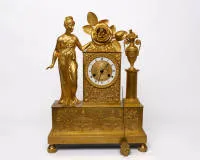 Figural mantel clock / figure clock, Empire, France, 1st half 19th c., gilded and richly ornamented case, rectangular clock head flanked by an amphora and Venus, Cupid looks out from the crowning rose blossom,...