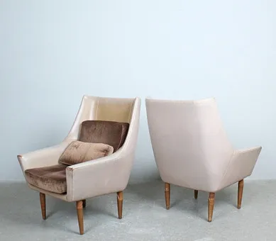 Paire de fauteuils avec revêtement en cuir et coussin en velours.
