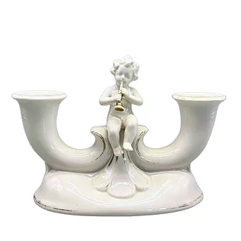 Bougeoir en porcelaine à deux bras avec un putto assis.