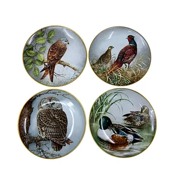 FRANKLIN MINT. VIER PORSELEINEN VERZAMELAARSBORDEN MET VERSCHILLENDE DIERENMOTIEVEN EN GOUDEN RAND.