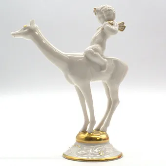 KARL TUTTER. FÜR HUTSCHENREUTHER "IDYLL" PUTTO AUF REH REITEND, GOLD DETAILS, ART DÉCO, DEUTSCHLAND.