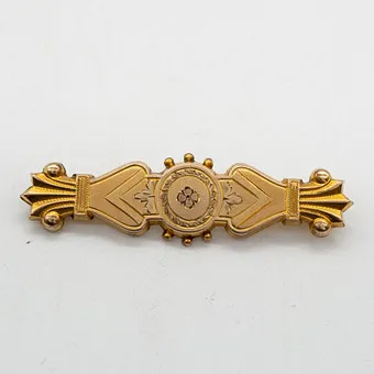 Victoriaanse designerbroche, gevuld met 10 karaat geelgoud, met graveerdecor, handgemaakt, keurmerk: 10 K I-20 GF TOP F.M. CO., eind 19e eeuw.