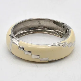 VINTAGE MODESCHMUCK ARMREIF AUS VERSILBERTEM METALL MIT EMAILLE, WEISS UND SILBER, FEDERVERSCHLUSS.