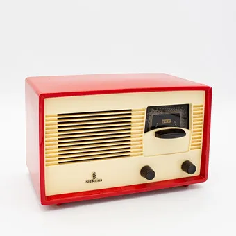 HISTORISCHE SIEMENS BUIZEN TAFELRADIO, MODEL SIEMENS SUPER A 60, JAREN 1950, BEHUIZING VAN ROOD KUNSTSTOF MET IVOORKLEURIGE VOORPLAAT, LUIDSPREKERROOSTER EN ZWARTE KNOPPEN.