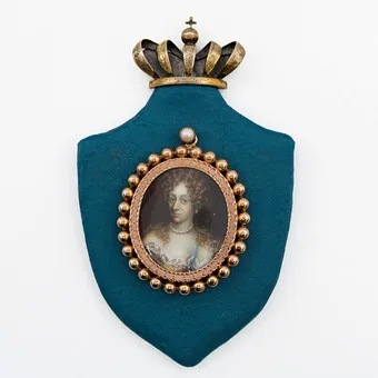 ANDREAS THORNBORG (1730-1780). CHARLOTTE AMALIE VON HESSEN-KASSEL (1650–1714), KÖNIGIN VON DÄNEMARK UND NORWEGEN, MINIATURGEMÄLDE (TEMPERA AUF PLATTE), VERGOLDETE MEDAILLONFASSUNG, AUF SCHILDFÖRMIGER PLATTE MONTIERT, KRONE AUS VERGOLDETEM SILBER, 17.–18. JAHRHUNDERT.