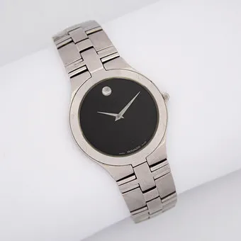 MONTRE-BRACELET MOCADO JURO, MOUVEMENT QUARTZ, ACIER INOXYDABLE AVEC CADRAN NOIR CARACTÉRISTIQUE, VERRE SAPHIR ANTI-RAYURES, ÉTANCHE JUSQU'À 30 MÈTRES, INDEX HORAIRE ARGENTÉ À 12 HEURES, BRACELET EN ACIER INOXYDABLE.