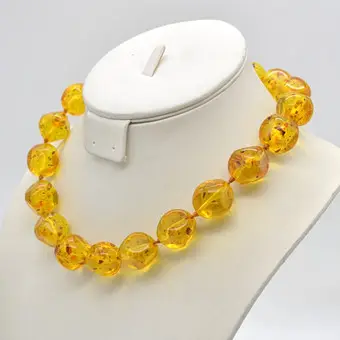 Gele barnsteen ketting, bladinsluitsels, individueel geknoopt, circa 1950.