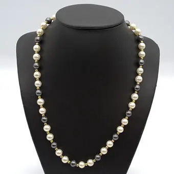 PERLENKETTE MIT IMITATIONSPERLEN,SCHWARZ, WEISS, VERGOLDETE TRENNSTÜCKE, UM 1950, CA. 50 CM.