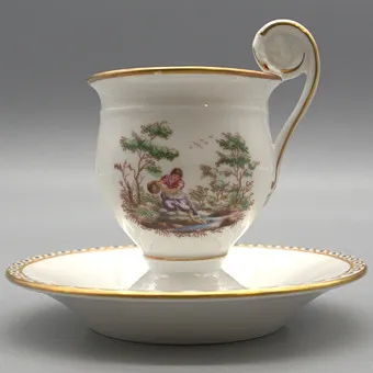 Richard Ginori. Ensemble tasse et soucoupe, peint à la main avec liseré doré, décor de scènes rurales.