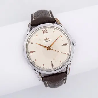 MARVIN ARMBANDUHR MIT MARVIN-UHRWERK, KALIBER 560 MIT 17 STEINEN, HANDAUFZUG, GEHÄUSE VERCHROMT, GEHÄUSEBODEN EDELSTAHL, 1950ER JAHRE, BRAUNES LEDERARMBAND.