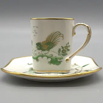 RICHARD GINORI. SET AUS TASSE UND UNTERTASSE, HANDBEMALT MIT GOLDRAND, VERZIERT MIT ZWEI VÖGELN.