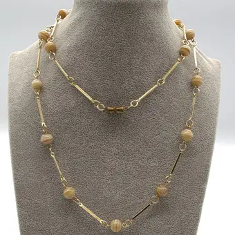 MURANO GLAS COLLIER,MIT CREMEFARBENEN, BERNSTEINFARBIGEN GLAS PERLEN UND VERGOLDETEN METALL VERZIERTEN ZWISCHENELEMENTEN UM CA. 1950 CA. 60 CM.