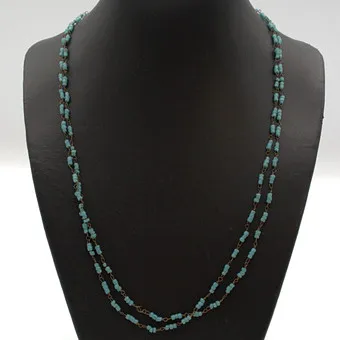 Lange ketting van turquoise glaskralen, rond, met messing tussenstukken, eindeloos, 20e eeuw, ca. 100 cm.