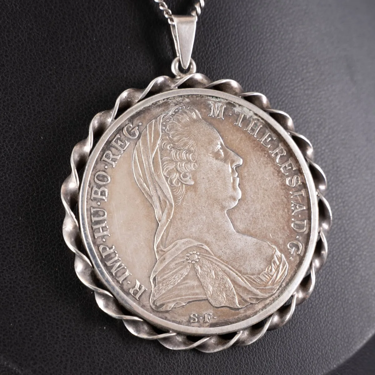 Thaler Marie-Thérèse en argent monté en pendentif sur chaîne à maillons d'environ 72 cm. Chaîne et monture en argent 835.