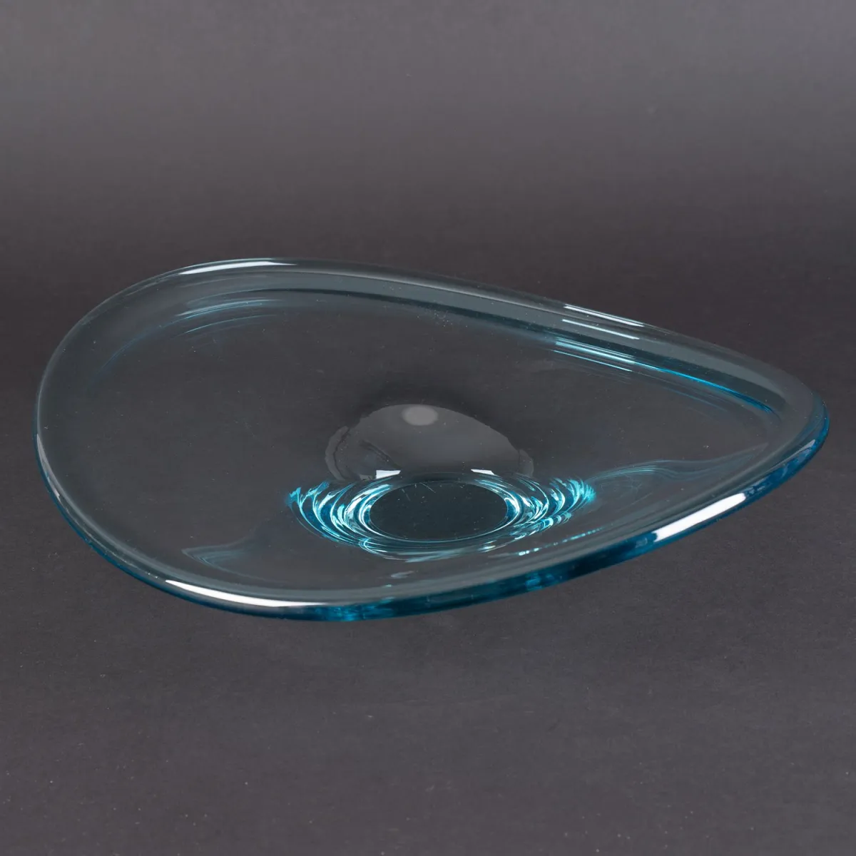 Owalna, wygięta misa ze szkła bezbarwnego na niebieskawej podstawie, sygnatura rytowana na dnie: R. (wys. ok. 9 cm, ok. 34 x 32 cm)