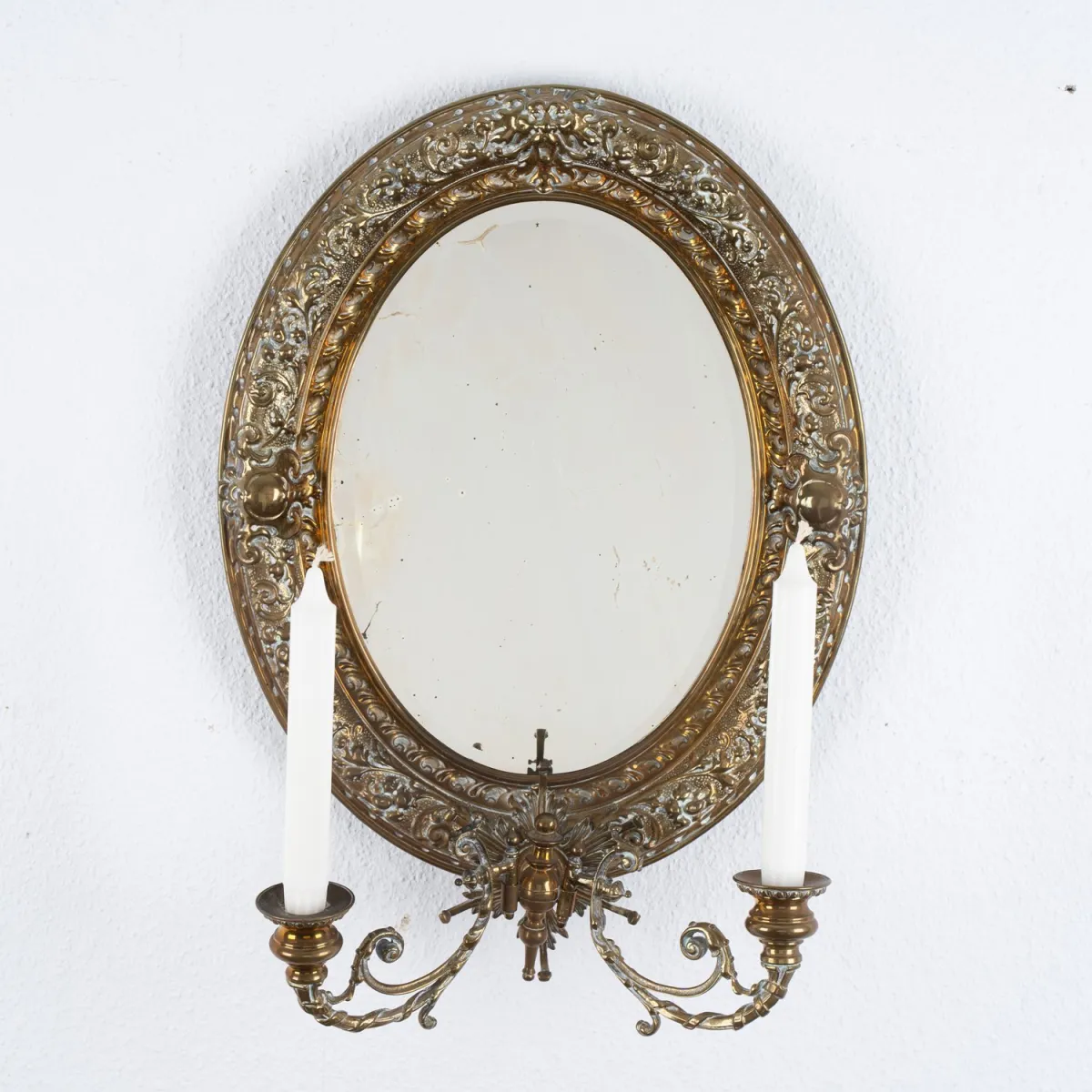 Ovaler Wandspiegel, Historismus / Gründerzeit um 1890, Messingblech, original facettiertes Spiegelglas, zwei einarmige K…