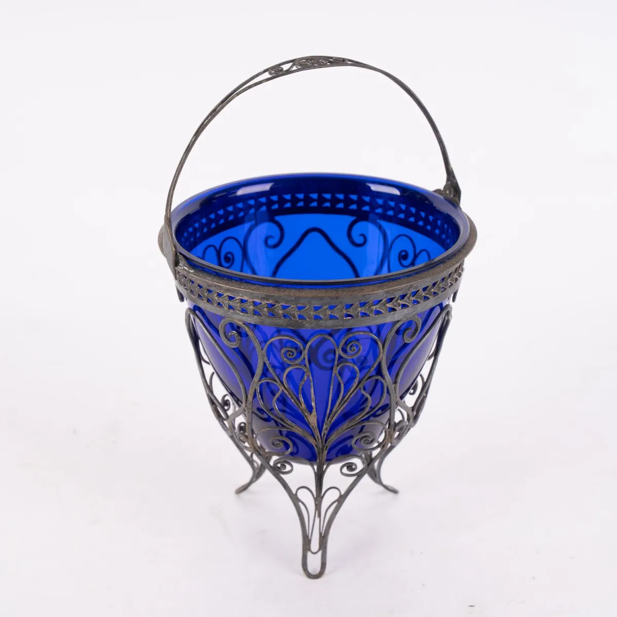 Timelessly elegant antique handled basket with original, undamaged blue-violet glass insert. The basket grid partially...