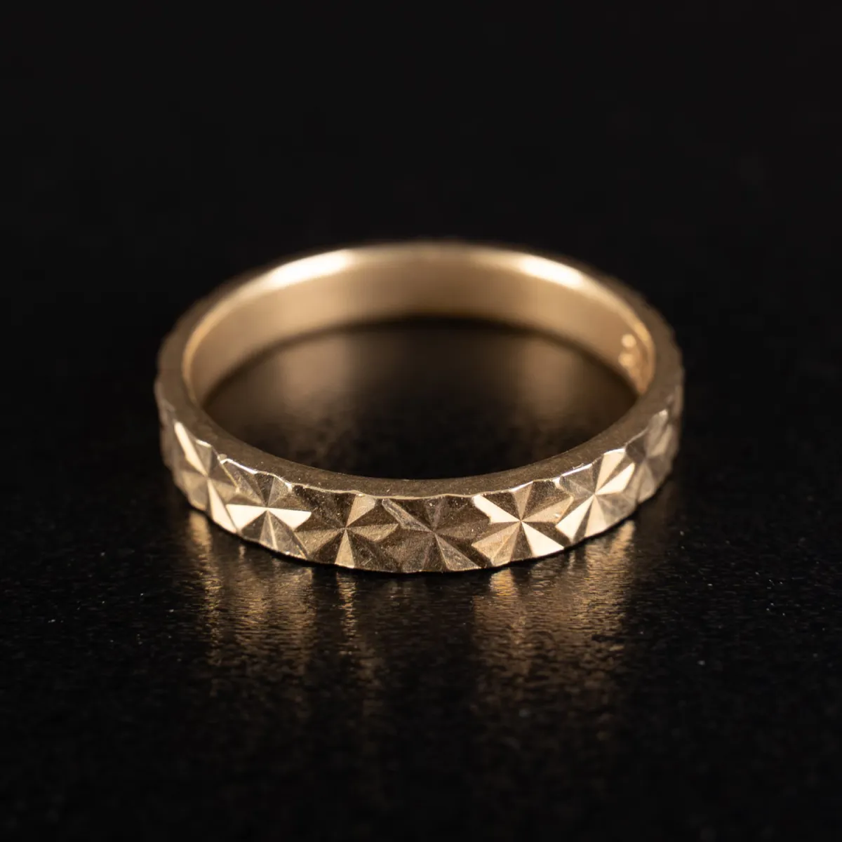 Ehe- oder Schmuckring aus 585er Gelbgold. Sternförmig geschliffene Oberflächenstruktur. Ringgröße ca. 66, Breite ca. 0,4…