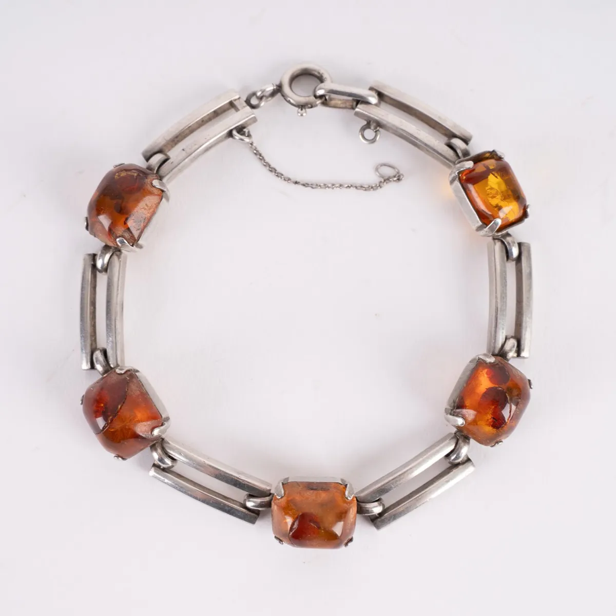 Silver bracelet with 5 amber cabochons in slightly rectangular shape. Rectangular chain links in simple design.