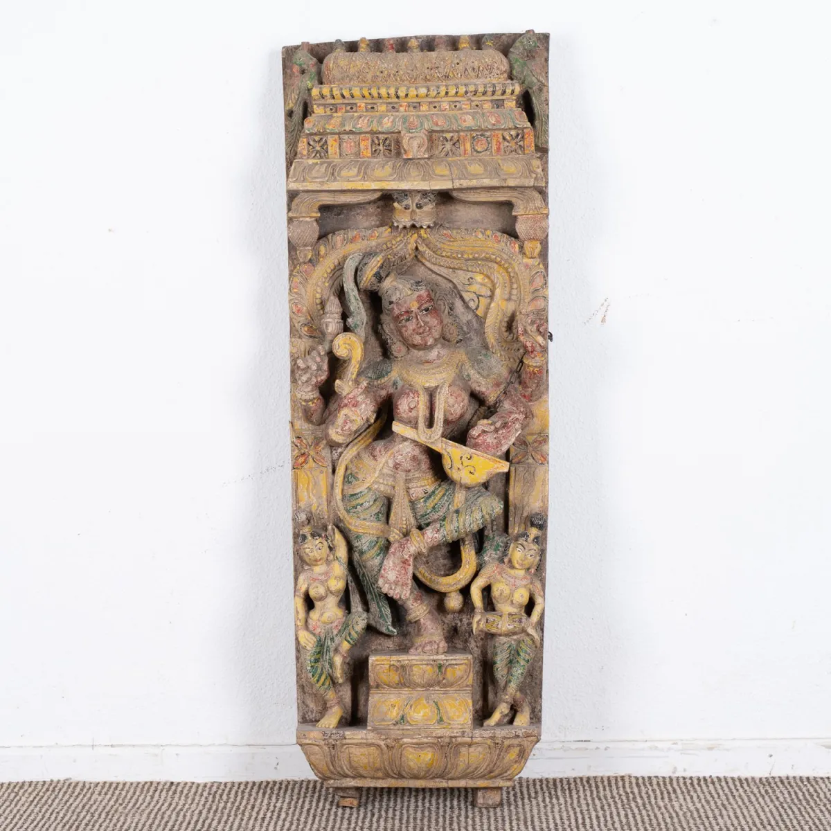 Rectangular carved panel, in muted colors, polychrome painted, India 20th c., approx. 108 x 28 x 13 cm.